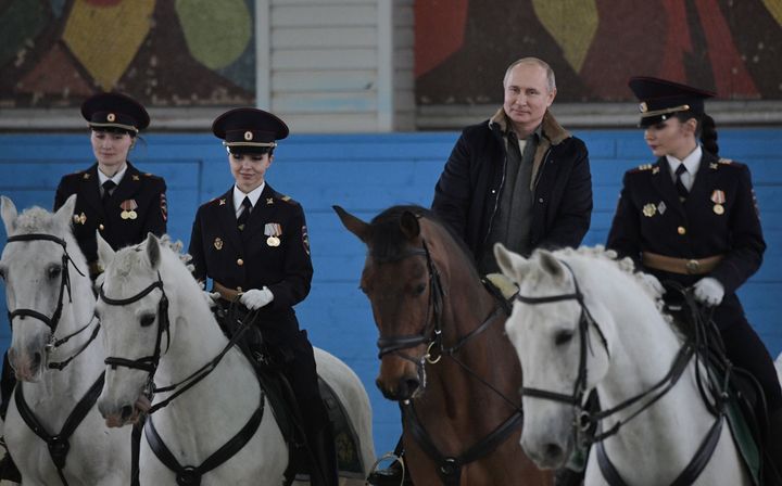 国際女性デーに合わせ、女性警察官らと乗馬するプーチン大統領＝3月7日、モスクワ