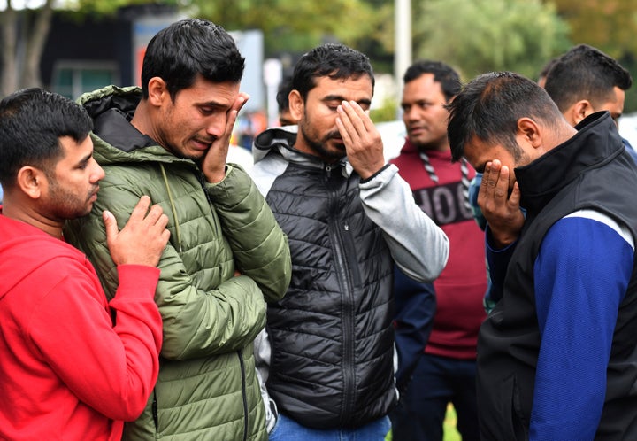 Friends of a missing man grieve outside a refuge center in Christchurch on Sunday.