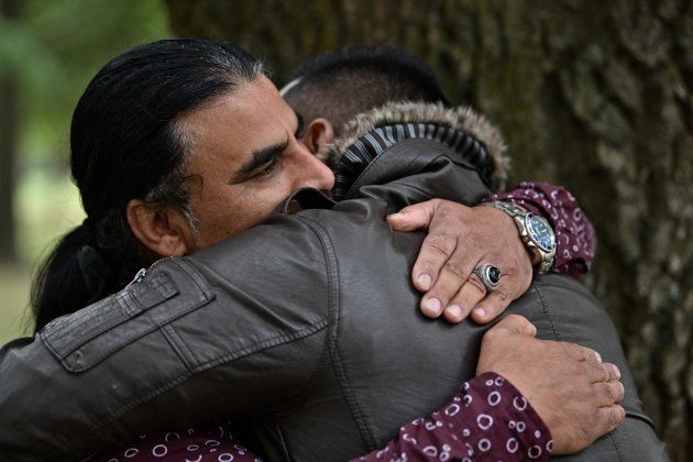 Abdul Aziz (L), 48, is greeted by a man who came to thank him for his bravery, during an interview with AFP in Christchurch.
