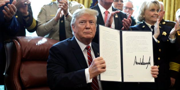 Donald Trump sostiene la carpeta con los documentos de su primer veto, hoy, en la Casa Blanca.