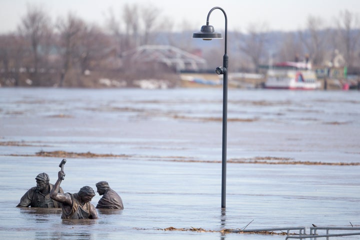 The high waters of the Missouri River almost cover figures in the Monument to Labor statue by Matthew J. Placzek, in Omaha, Neb., on March 16, 2019.