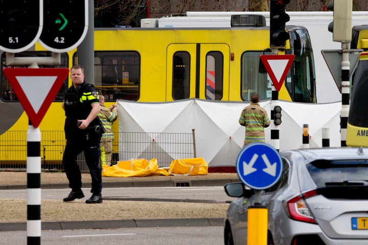 Rescue workers install a screen on the spot where a body was covered with a white blanket following a shooting in Utrecht, Ne