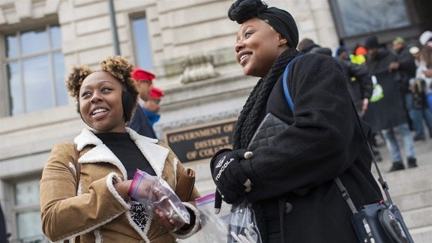 Sisters Jackie, left, and Bria Cook, hand out marijuana cigarettes at a rally in Washington, D.C, to push for changes to the