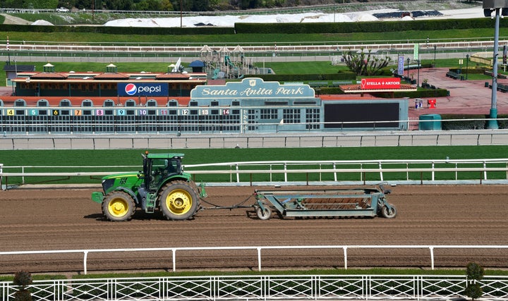A tractor is driven at the Santa Anita Racetrack where races were suspended after multiple horse deaths. The track has since