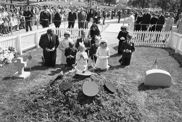 O Ρόμπερτ Κέννεντυ γονατίζει μαζί με την οικογένειά του, στον τάφο του δολοφονημένου αδελφού του Τζον Κέννεντυ (JFK) τον Μάιο του 1964. 