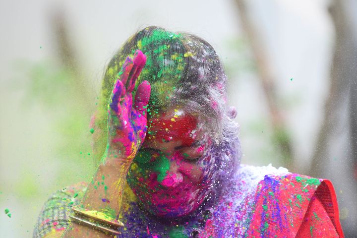 A woman smeared in colours during Holi celebrations in Agartala. 