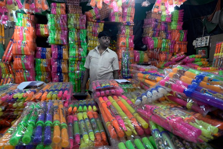 A shopkeeper sells colours and water guns in a shop in Kolkata. 