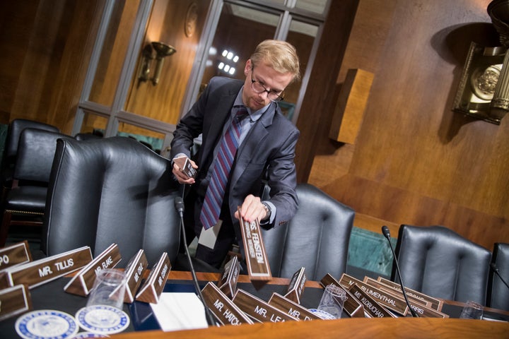 A Senate staffer arranges nameplates in the Senate Judiciary Committee hearing room on Sept. 26, 2018.