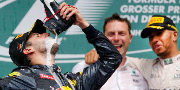 Australian Red Bull driver Daniel Ricciardo drinks champagne out of his shoe after finishing second in...