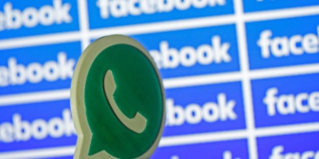 A 3D printed Whatsapp logo is seen in front of a displayed Facebook logo in this illustration taken April...