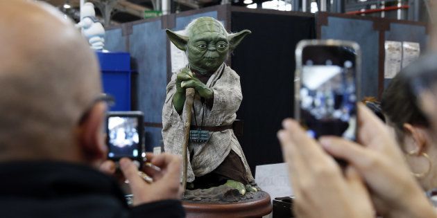 Des fans devant une statue de Yoda au Comic Con 2015 à