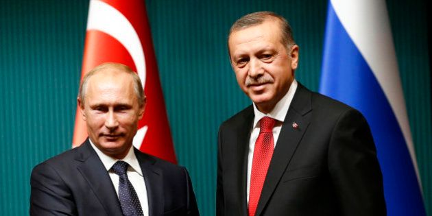 Russia's President Vladimir Putin (L) shakes hands with Turkey's President Tayyip Erdogan after a news...
