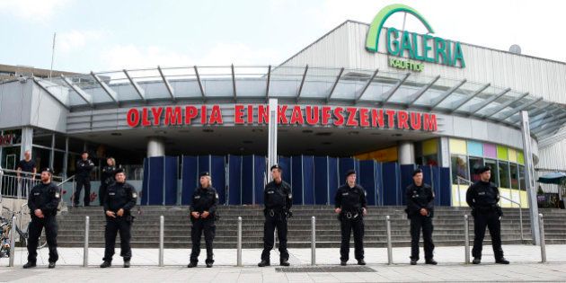 Police stand guard outside the Olympia shopping mall, where yesterday's shooting rampage started, in...