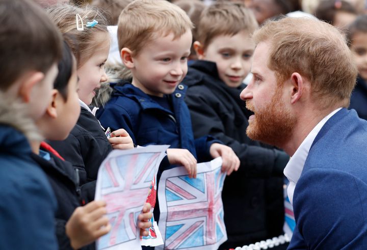 Prince Harry greets pupils from St. Vincent's Catholic Primary School before planting a tree.