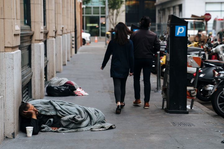 People walk by homeless people sleeping on the streets of San Francisco, California -- Aug. 23, 2018.