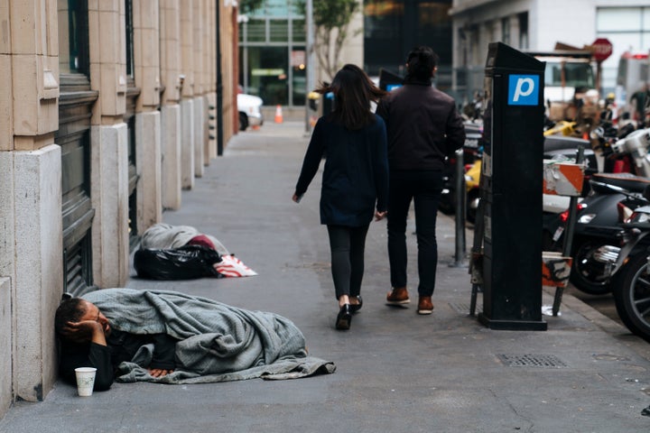 People walk by homeless people sleeping on the streets of San Francisco, California -- Aug. 23, 2018.