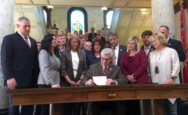 Mississippi Gov. Phil Bryant is surrounded by lawmakers on Thursday, March 21, 2019, as he signs a bill that would ban most abortions once a fetal heartbeat can be detected, at the capitol in Jackson, Miss. The bill is set to become law July 1, 2019 and would be one of the strictest abortion laws in the nation. The Center for Reproductive Rights calls the law unconstitutional and says it will sue Mississippi to try to block the law from taking effect. (AP Photo/Emily Wagster Pettus)