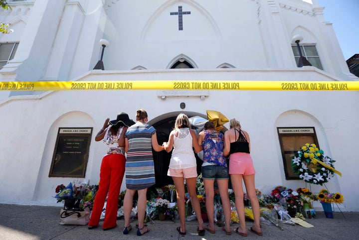 In this June 18, 2015, file photo, a group of women pray together at a makeshift memorial on the sidewalk in front of the Emanuel AME Church, in Charleston, S.C. Dylann Roof fatally nine people in a racist attack at the South Carolina church. The government did not bring federal terrorism charges against him.