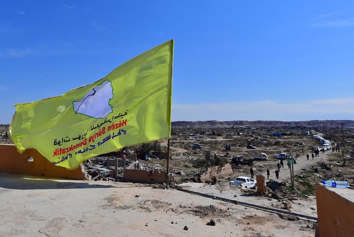 A picture taken on March 23, 2019 shows the US-backed Syrian Democratic Forces' (SDF) flag atop a building in the Islamic State group's last bastion in the eastern Syrian village of Baghuz after defeating the jihadist group.
