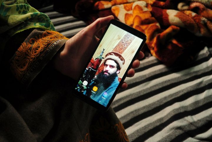 Sister of Owais Malik shows a picture of him on her phone. 