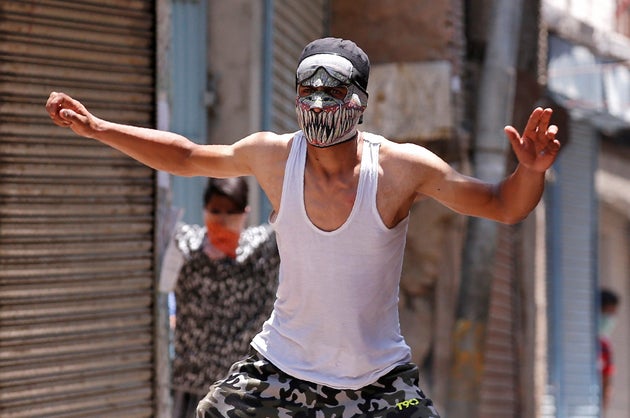 A masked protester reacts during a clash with police on the occasion of the death anniversary of Burhan