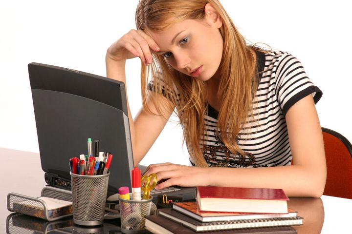 Girl, at table, having trouble studying