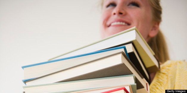 USA, New Jersey, Jersey City, Woman carrying stack of books