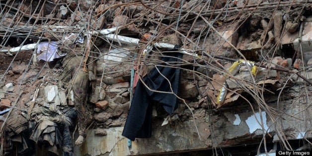 The bodies of Bangladeshi garment workers lie crushed under rubble after an eight-storey building collapse in Savar, on the outskirts of Dhaka,on May 2, 2013. Bangladesh authorities have suspended the mayor of Savar satellite town outside the capital for approving the faulty construction of a building that collapsed last week, killing 429 people. AFP PHOTO/ Munir uz ZAMAN (Photo credit should read MUNIR UZ ZAMAN/AFP/Getty Images)