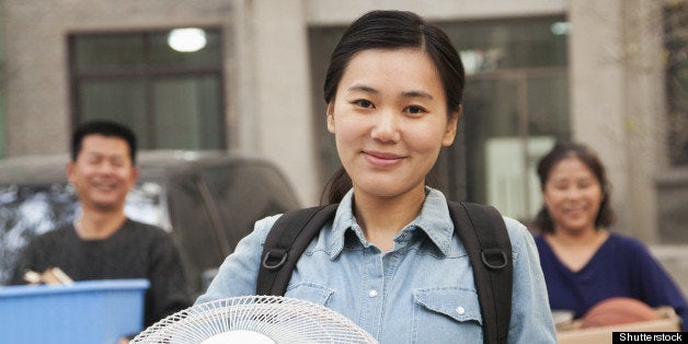 Student portrait in front of dormitory at college with family