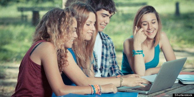 Group of Teenage Students at Park with Computer and Books