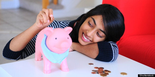 happy indian girl putting coins ...