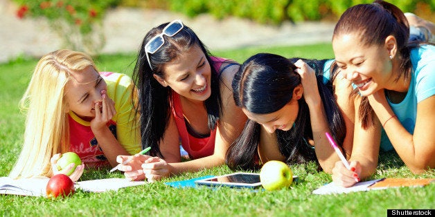 four beautiful girl having fun outdoors on green lawn