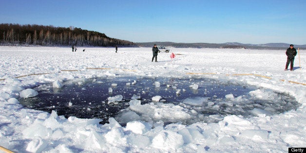 CHELYABINSK, RUSSIA - FEBRUARY 17: (CHINA OUT, SOUTH KOREA OUT) A hole, thought to be made by the fragment of the meteor in the ice of Chebarkul Lake is seen on February 16, 2013 some 80 kilometers from Chelyabinsk, Russia. Local government reported more than 1,100 people injured, mostly by flying glass broken by the shock wave of the meteor explosion. (Photo by The Asahi Shimbun via Getty Images)