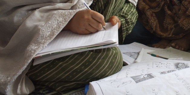 An adult literacy class, at Dust-e-Noor neighborhood, in Mazar-e-Sharif, in the northern province of Balkh. Dari is the Afghan dialect of the Persian or Farsi language. A total of 50 women attend the literacy centre, one of 7,000 such centers in the province. Nationwide, 48,000 women participate in the literacy program. Afghanistan. June 28, 2007. (Photo by: Majority World/UIG via Getty Images)