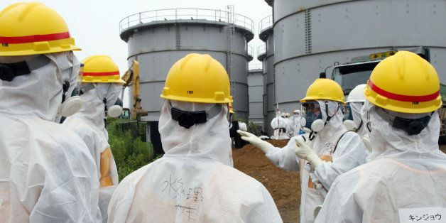 Japan's nuclear watchdog members, including Nuclear Regulation Authority members in radiation protection suits, inspect contaminated water tanks at the Tokyo Electric Power Co (TEPCO) Fukushima Dai-ichi nuclear power plant in the town of Okuma, Fukushima prefecture on August 23, 2013. Japan's nuclear watchdog dispatched an inspection team to the crippled Fukushima plant after workers found a huge toxic water leak and unexplained radiation hotspots. Earlier this week around 300 tonnes of radioactive liquid is believed to have escaped from one of the hundreds of tanks that hold polluted water, some of which was used to cool the broken reactors, in an episode dubbed the most serious in nearly two years. JAPAN OUT AFP PHOTO / JAPAN POOL via JIJI PRESS (Photo credit should read JAPAN POOL/AFP/Getty Images)