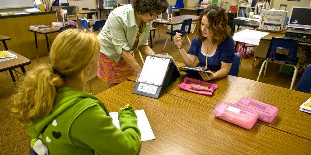 A mentor special education teacher in a Southern California middle school instructs a colleague in administering a psychological test to a student