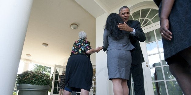 US President Barack Obama hugs a woman who will benefit from health insurance plans under the Affordable Care Act after speak