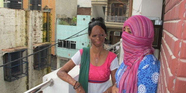 NEW DELHI, INDIA - JULY 30: Laxmi Aggarwal (23), and Nasreen (one name, 33) in the balcony of the new campaign office Stop Acid Attacks in New Delhi. Aggarwal was only 16 when a man threw acid on her face and hands for refusing his proposal. She remained hidden behind the veil for many years. But this year, buoyed by the anti-rape protests and a new law against acid attacks, Aggarwal found the courage to come out and join the campaign. Since then she has become a sort of the poster-child of the campaign against acid attacks. For the first time, India established specific penalties for the crime, and now the Supreme Court directed the government two weeks ago to regulate acid sales and award quick money for medical treatment for the survivors. Not to lose on the momentum generated by the anti-rape activism and the new law, acid attack survivors are now coming together to push the government to enforce the court's orders, demand rehabilitation and planning street plays to raise awareness about the prevalence of the crime in Indian cities. 'It is very important to show the face, people should see the horror. Hiding the face is the same as staying silent,' Aggarwal said. (Photo by Rama Lakshmi/The Washington Post via Getty Images)