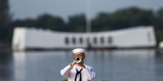PEARL HARBOR, HAWAII - DECEMBER 7: A U.S. Navy musician plays echo 'Taps' in front of the U.S.S. Arizona Memorial during th