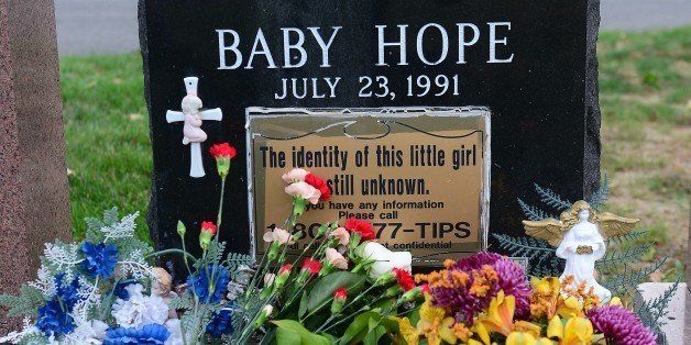The grave of 'Baby Hope,' an unidentified girl whose body was found murdered in a picnic cooler 22 years ago, is adorned with flowers at St. Raymond Cemetery in New York, October 11, 2013. New York police have at last identified a little girl who was murdered, sexually abused and stuffed into a picnic cooler in Manhattan. She was found on July 23, 1991. New York police officials confirmed the identity of the girl's mother through DNA testing on October 8, 2013, and also identified the father. The family is Mexican and her mother was too frightened to come forward after her daughter's death, because her husband was abusive, local media reports said. The girl's father, who is believed to be either in New York or Mexico, is now the prime suspect. Baby Hope, two years after she was found, was laid to rest in a donated plot. AFP PHOTO/Emmanuel Dunand (Photo credit should read EMMANUEL DUNAND/AFP/Getty Images)