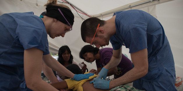 German International Search and Rescue team doctors treat a typhoon victim at the advance medical post in Palo on November 20, 2013. The United Nations has confirmed at least 4,500 killed by typhoon Haiyan, which brought five-metre (16-foot) waves to Tacloban, flattening nearly everything in their path as they swept hundreds of metres across the low-lying land. AFP PHOTO/ Nicolas ASFOURI (Photo credit should read NICOLAS ASFOURI/AFP/Getty Images)