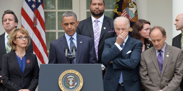 US President Barack Obama is accompanied by former lawmaker Gabrielle Giffords (L), vice president Joe Biden (R) and family members of Newtown school shooting victims as he speaks on gun control at the Rose Garden of the White House in Washington, DC, on April 17, 2013. Obama on Wednesday slammed what he called a 'minority' in the US Senate for blocking legislation that would have expanded background checks on those seeking to buy guns. AFP PHOTO/Jewel Samad (Photo credit should read JEWEL SAMAD/AFP/Getty Images)