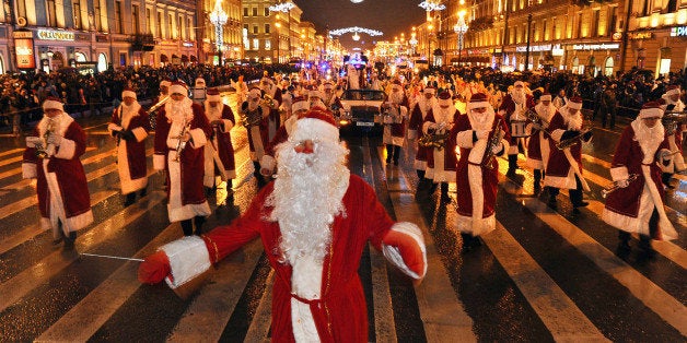 Musicians wearing Santa Claus costumes march along Nevsky Prospect during a New Year's eve festival parade in central St. Pet