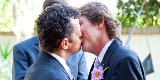 handsome gay couple kissing at...