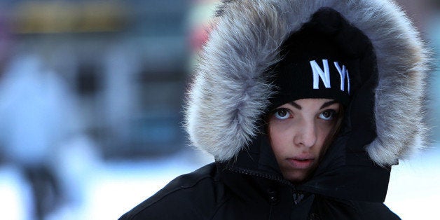 NEW YORK, NY - JANUARY 03: A woman walks through a cold and snow covered Times Square following a snow storm that left up to