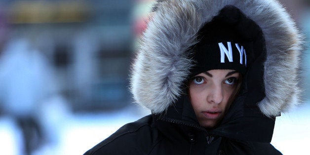 NEW YORK, NY - JANUARY 03: A woman walks through a cold and snow covered Times Square following a snow storm that left up to 8 inches of snow on January 3, 2014 in New York, United States. The major winter snowstorm, which forced New York City public schools to close and shut down the Long Island Expressway, is being viewed as a test for the new mayor of New York City Bill de Blasio. Dangerously cold temperates are predicted for the day and evening hours. (Photo by Spencer Platt/Getty Images)