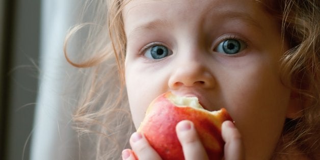 adorable little girl eating red ...