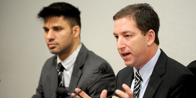 The Guardian's Brazil-based reporter Glenn Greenwald (R), who was among the first to reveal Washington's vast electronic surveillance program, accompanied by his partner David Miranda testifies before the investigative committee of the Senate that examines charges of espionage by the United States in Brasilia on October 9, 2013, following press reports of US electronic surveillance in Brazil based on leaks from Edward Snowden, a former US National Security Agency contractor. AFP PHOTO/Evaristo Sa (Photo credit should read EVARISTO SA/AFP/Getty Images)