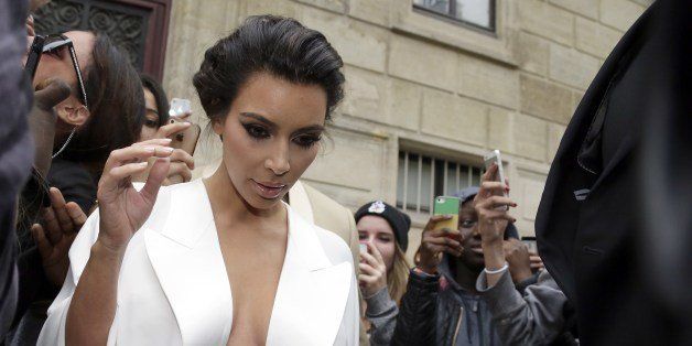 American reality TV star Kim Kardashian leaves her residence in Paris on May 23, 2014, ahead of their wedding. American singer Kanye West and his bride-to-be Kim Kardashian lunched on May 23 at a French chateau owned by iconic designer Valentino, kicking off a marathon celebration expected to culminate in the wedding of the year. AFP PHOTO / KENZO TRIBOUILLARD (Photo credit should read KENZO TRIBOUILLARD/AFP/Getty Images)