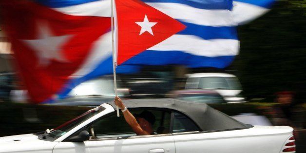 MIAMI - AUGUST 1: A motorist waves a Cuban flag while cruising down the famous Calle Ocho in the Little Havana neighborhood August 1, 2006 in Miami, Florida. Cuban Americans were celebrating the news that Fidel Castro had turned over power to his younger brother, Raul Castro, while he undergoes medical treatment for intestinal bleeding. (Photo by Chip Somodevilla/Getty Images)
